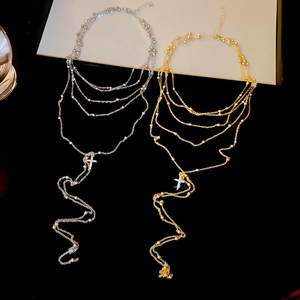 Detail of layered gold and silver cross necklaces with tassels and cubic zirconia