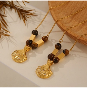Detail of vintage shell-shaped pendant with diamonds and brown tiger eye stone beads
