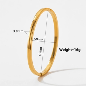 Vista detallada de un brazalete ovalado dorado de acero con dimensiones y peso especificado.