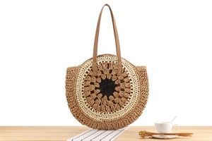 Close-up of woven straw shoulder bag featuring intricate circular sunflower pattern detail