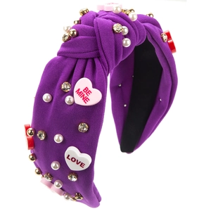 Détail d'un serre-tête violet noué orné de perles, strass et écussons en forme de cœur