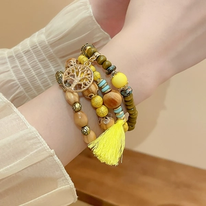 Close-up of bohemian multilayer sandalwood bracelet with tree of life charm and tassel