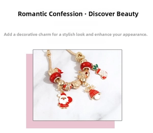 Detail of Christmas charm bracelet with Santa, bells, and red beads on gold snake chain