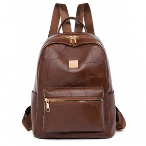Detail view of deep brown patchwork leather backpack with elegant gold hardware and straps