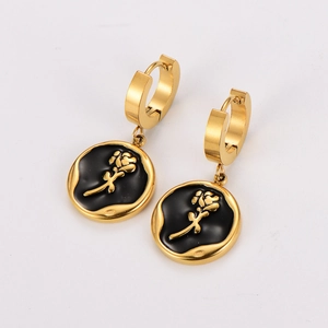 Detail of gold earrings featuring black enamel with a 3D embossed rose flower pattern