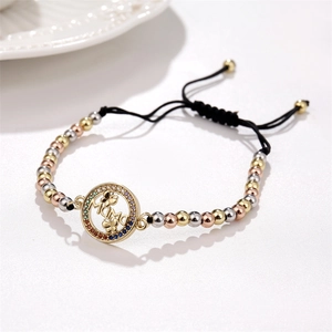 Détail de perles métalliques tricolores avec pendentif MAMA papillon sur bracelet cordon