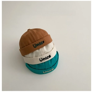 Vista dettagliata di cappelli docker in cotone per bambini con ricamo Unice in tre colori