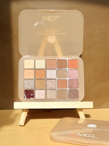Close-up of a 20-color eyeshadow palette with matte and shimmer textures on a mini easel