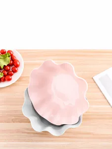 Detail of petal-shaped plastic snack bowls in pink and gray with wavy ruffled edges