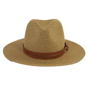 Macro view of woven Panama straw hat with brown leather band and gold buckle detail