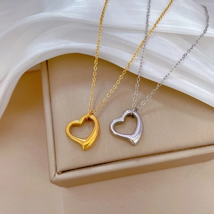 Elegant gold and silver minimalist open heart pendant necklaces on white silk