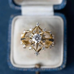 Detailed macro of golden starburst ring with round zircon in a blue velvet box