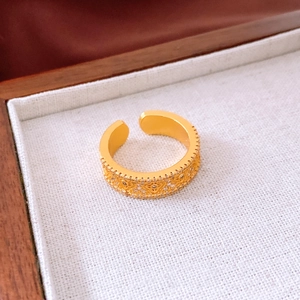 Detailed close-up of 24K gold plated flower ring with micro-pave stones and open band
