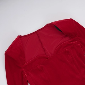 Detail view of the red velvet fabric texture and stitching on the elegant dress