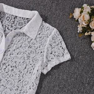 Detail of white lace short sleeve polo top with intricate hollow crochet and buttons