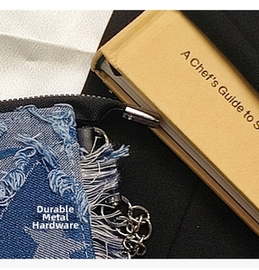 Detail of star-patterned denim bag featuring frayed edges and silver metal hardware