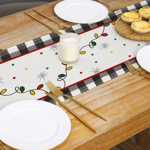 Christmas table runner with buffalo plaid edges and festive bulb prints on wooden table