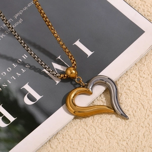 Detailed view of two-tone gold and silver heart pendant on a mixed link chain