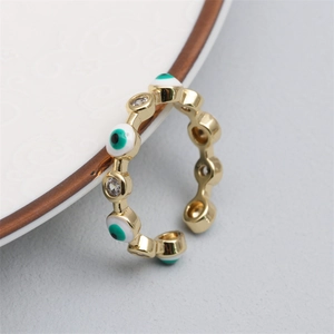 Macro shot of gold adjustable ring featuring a pavé zircon heart and enamel evil eye detail