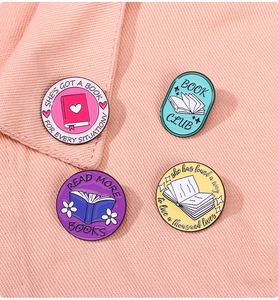 Detailed macro view of four colorful enamel book badges on pink denim fabric background