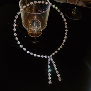 Macro shot of silver Y-shape choker with pear-cut zirconia droplets and tassels