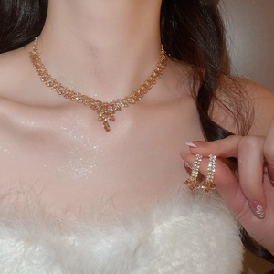 Detail showing golden wheat ear tassel jewelry set with zircon crystals on a model