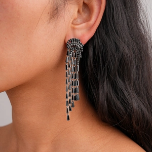 Close-up of long black rhinestone jellyfish tassel earrings worn by a model
