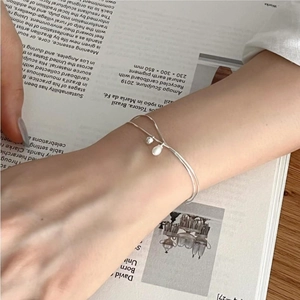 Detail of minimalist S925 sterling silver pearl bracelet worn by model on magazine