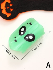 Detailed size view of green alien hair claw clip with black eyes and star patterns