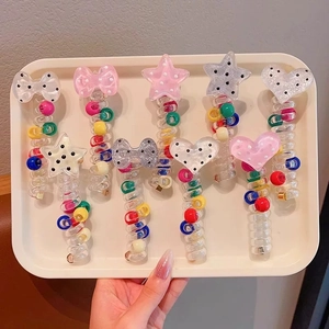 Close-up of colorful spiral phone line hair ties with pearl beads and heart charms