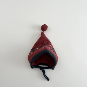 Detail of baby knitted hat with red pompoms, star patterns, and windproof chin straps