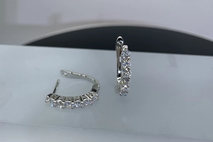 Macro shot of silver hoop earrings with pave-set moissanite stones and needle closure
