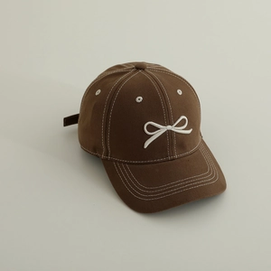 Vue détaillée de la casquette marron avec broderie nœud blanc et surpiqûres blanches
