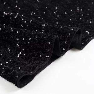 Detailed macro view of black sequin embroidery fabric with high metallic luster