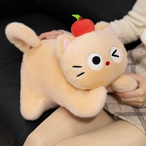 Cute beige apple cat plush doll with red apple hat and playful winking expression on sofa