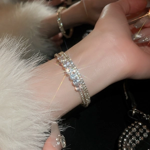 Detail of multi-layer sparkling zircon bracelet with five large diamonds on a female wrist