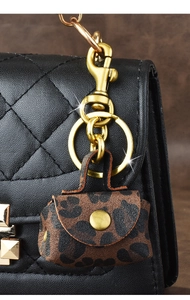 Detail of leopard print mini bag charm with golden metal clasp and snap closure