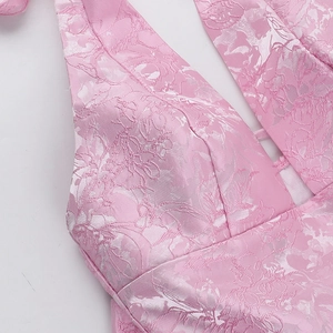 Close-up of pink jacquard fabric with rose patterns and halter neck bow detail