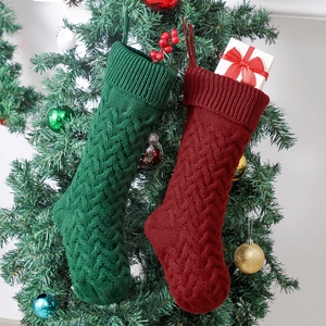 Red and green 46cm cable knit Christmas stockings with gift box on a festive background