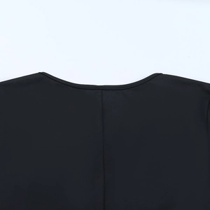 Dettaglio dello scollo rotondo e delle cuciture su un abito nero a maniche lunghe con cut-out