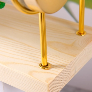 Detail of solid wood base and golden metal rod connection on multi-tier jewelry rack