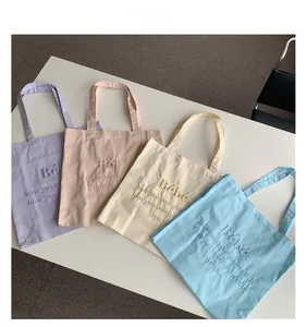Flache Ansicht bunter Canvas-Tragetaschen mit Bebe-Stickerei und Pastelltönen