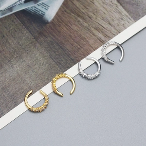 Detailed view of silver and gold U-shaped ear cuffs with micro-set cubic zirconia stones