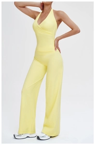 Detail of light yellow yoga set featuring high-waist flared pants and V-neck halter top