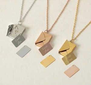 Detailed view of silver, gold, and rose gold envelope necklaces with Love You engraving