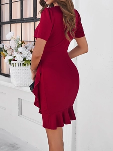 Close-up of a red fitted dress showing the ruffled hemline and elegant back silhouette