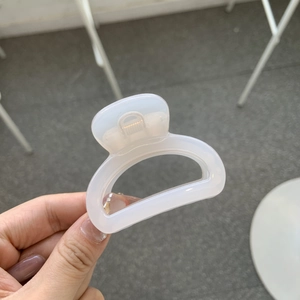 Translucent white butterfly claw clip for high ponytail styling on a plain background