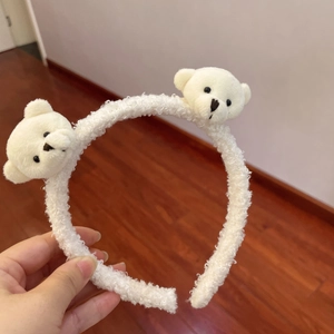 Close-up of white plush headband featuring two cute stuffed bears on a fuzzy band
