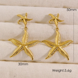 Detail view of 14K gold starfish drop earrings with texture and 50mm size dimensions