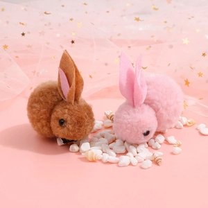 Cute plush bunny hair clips in pink and brown, set on a decorative starry tulle background